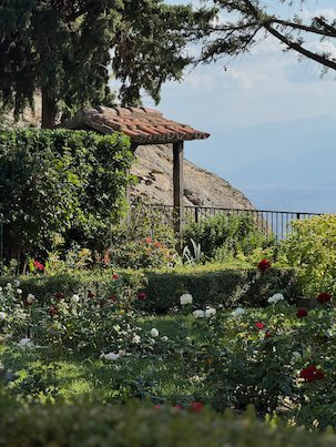 Monastery garden with roses and a view over the valley at Meteora