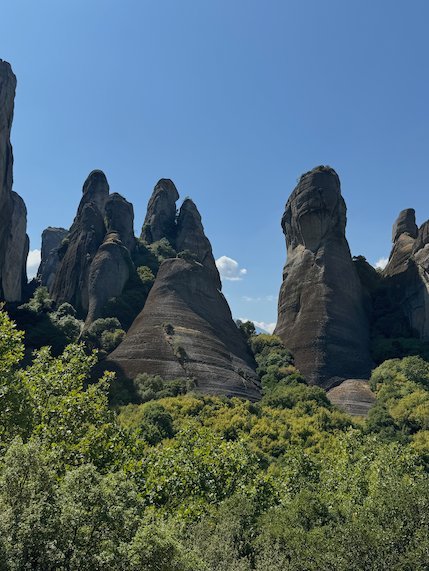 Sharp rock pinnacles above a green forest at Meteora