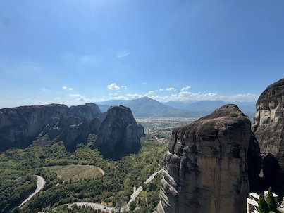 Rocks of Meteora and a winding road in the green valley below