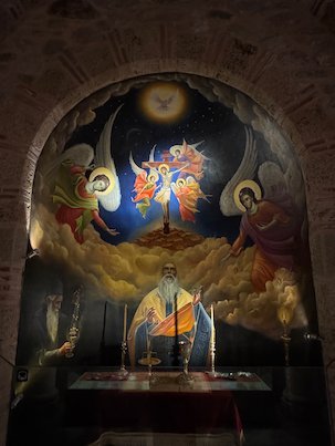 Wall painting of angels above a seated monk in a Meteora monastery