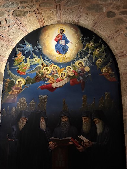 Wall painting of Christ with angels and saints above monks in a Meteora monastery
