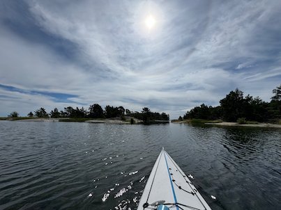 Kayak bow pointing to a narrow passage between low islands