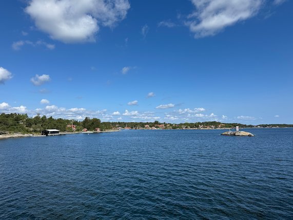 Wide bay with islands and summer houses under a blue sky