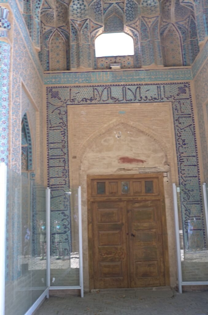 Tiled portal with an old wooden door at the Jameh Mosque of Natanz