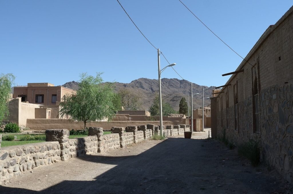 Quiet street with trees and mountains in Natanz