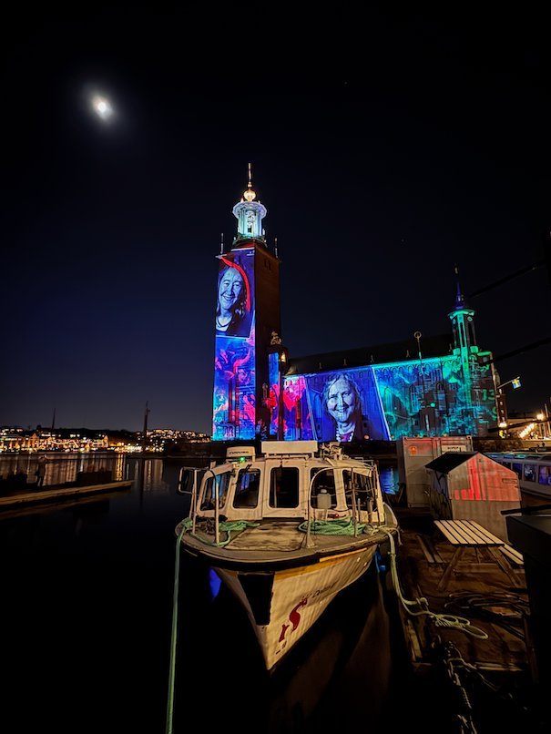 Portraits of Nobel laureates projected on the tower and facade of Stockholm City Hall at night
