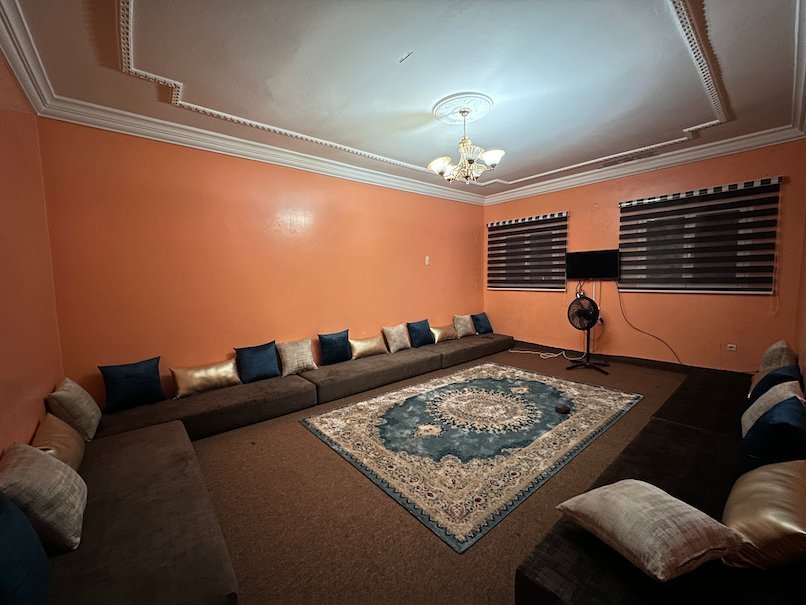 Floor cushions line the walls of an orange sitting room in Nouakchott.