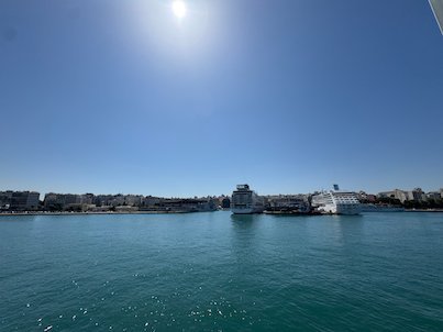 Piraeus harbor with a cruise ship under a bright sun