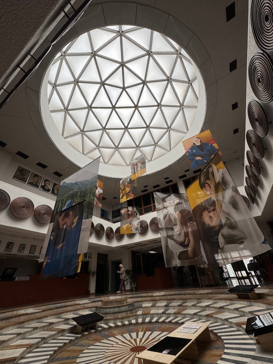 Banners hang below a geodesic glass dome in the atrium of the National Library in Pristina.