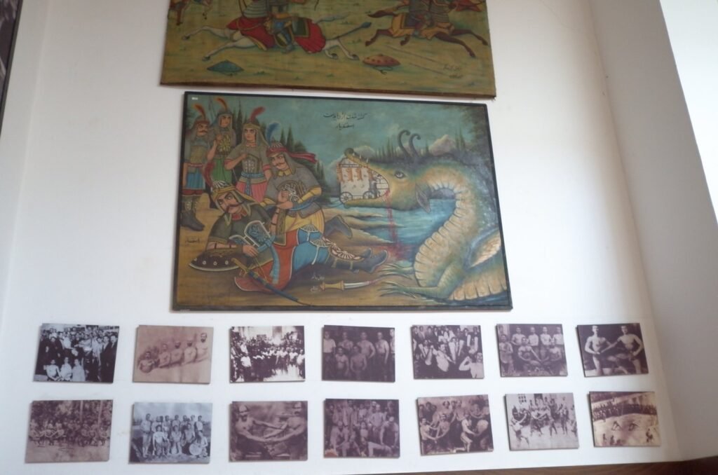 Wall with a painting and old black and white photos at the Qasr Prison Museum
