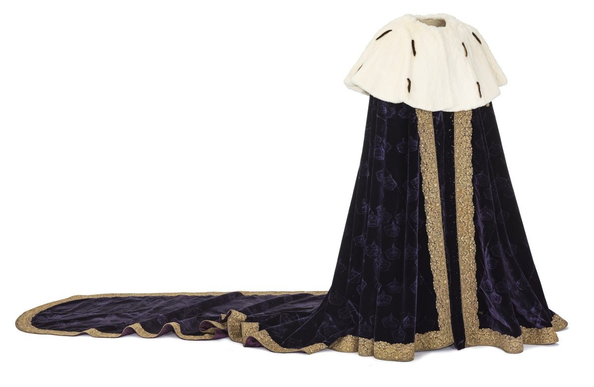 Queen Kristina's coronation mantle of dark purple velvet with a broad gold border, a white fur collar and a long train. Faint outlines show where small crowns were once sewn on.