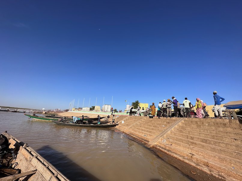 People wait at the river landing for pirogues to cross the Senegal River.