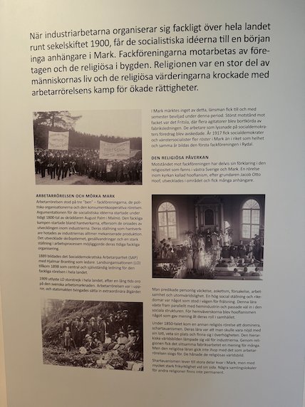 Exhibition wall text in Swedish about the labour movement and old photos of workers