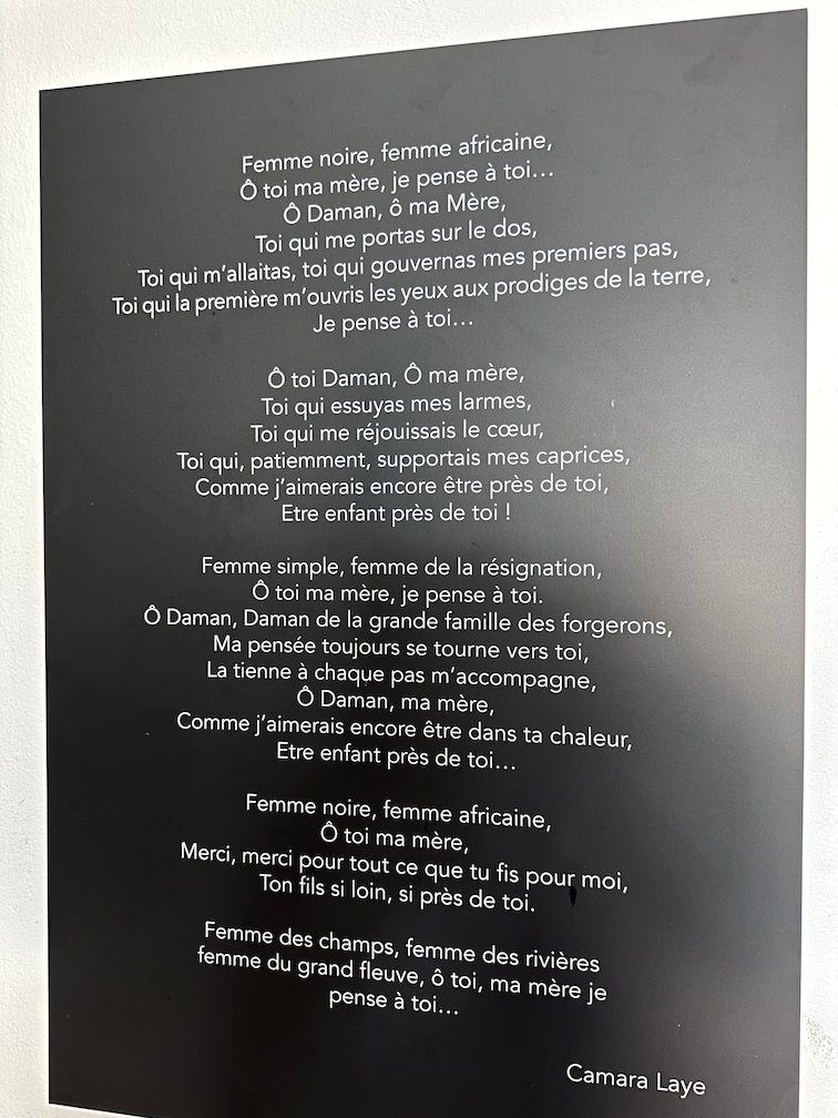 A black panel shows a poem by Camara Laye in a museum in Saint-Louis.