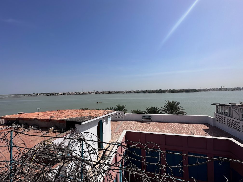 A rooftop terrace looks out over the wide Senegal River in Saint-Louis.