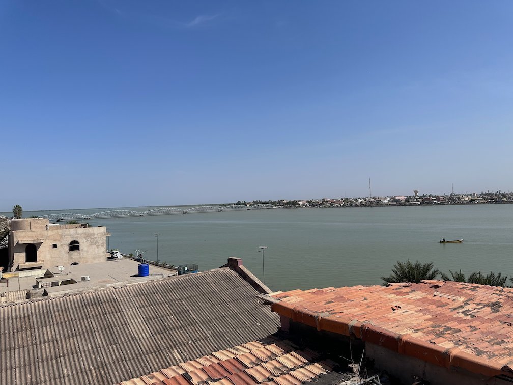 Red roofs and the Senegal River are seen from a rooftop in Saint-Louis.