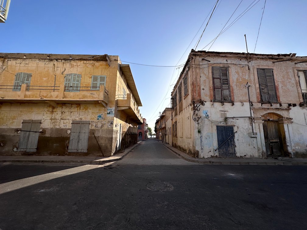 Old houses stand on a street corner in the island town of Saint-Louis.