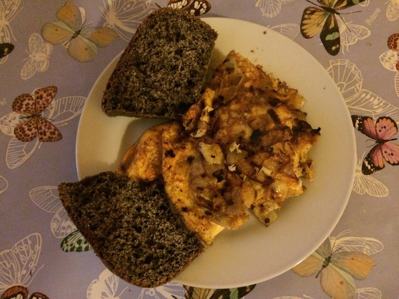 An omelette with two slices of dark bread lies on a plate in Sardinia.