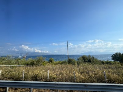 Sea and dry grass seen through the bus window on the road to Meteora