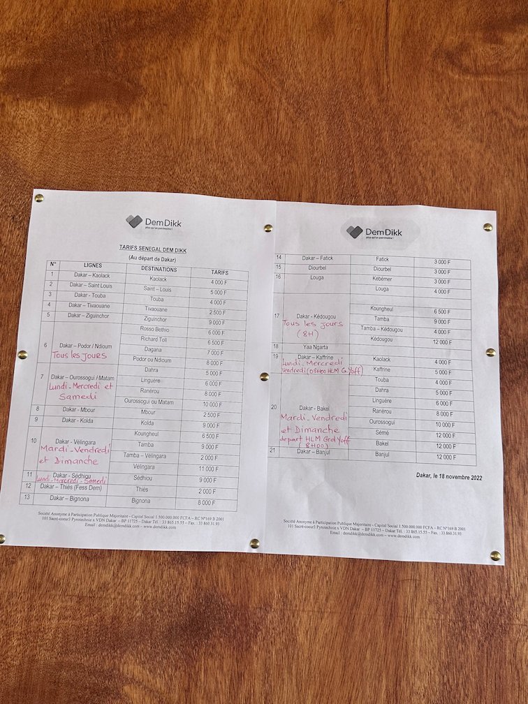 A printed passenger list lies on a wooden table.