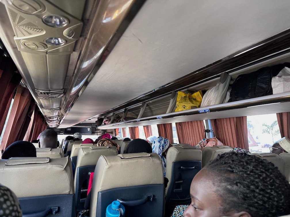 Passengers sit in a coach bus with luggage racks in Senegal.