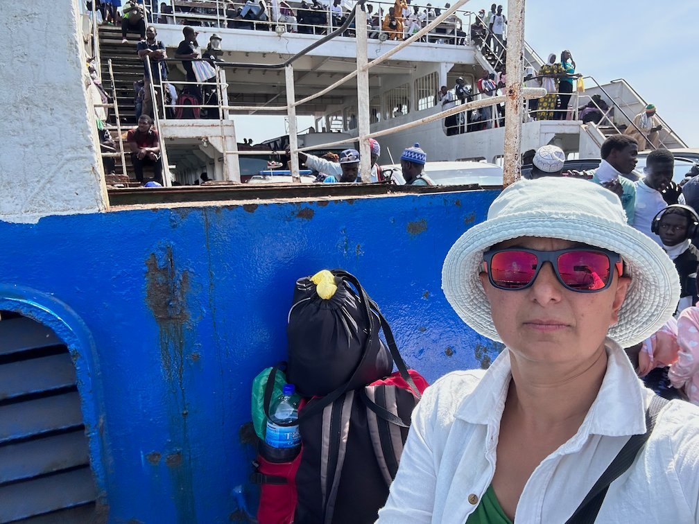 Zayera Khan takes a selfie next to bags on a crowded boat.