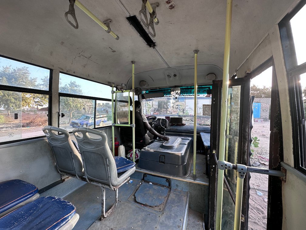 An old bus with blue seats stands empty in Senegal.