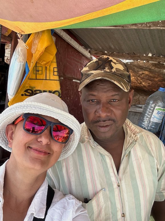 Zayera Khan takes a selfie with a local man at a market stall.