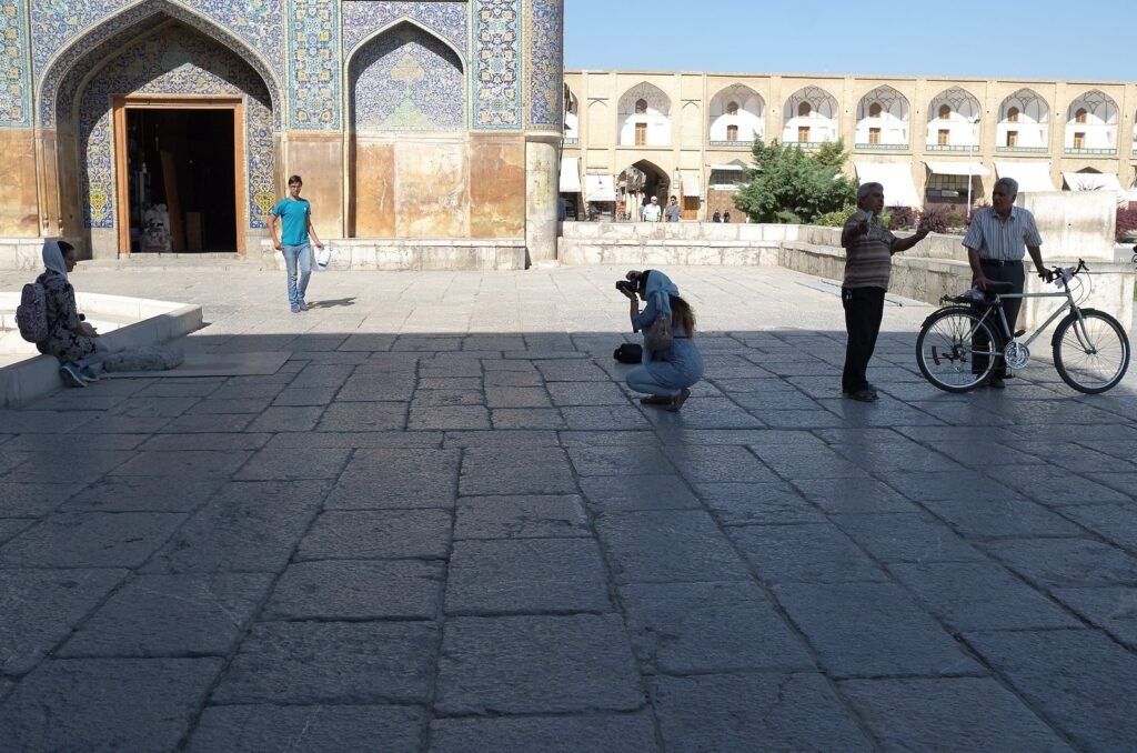Visitors and a photographer at the entrance of the Shah Mosque
