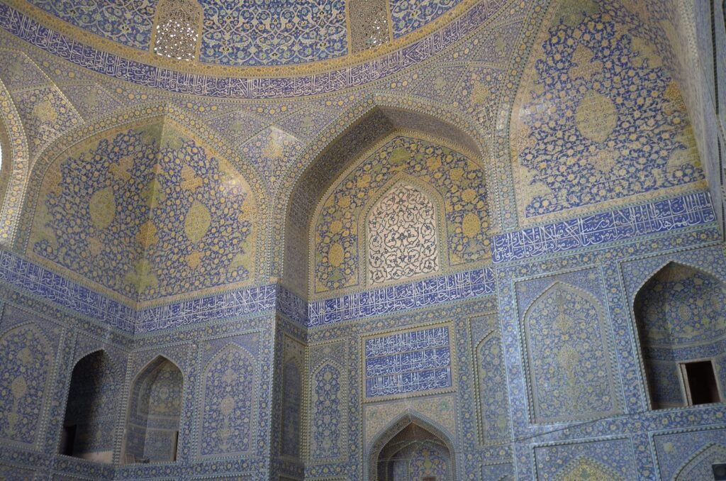 Walls covered in blue and yellow tiles in the Shah Mosque