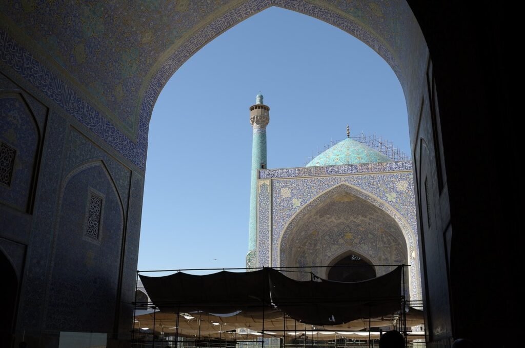 Dome and minaret of the Shah Mosque seen through an arch