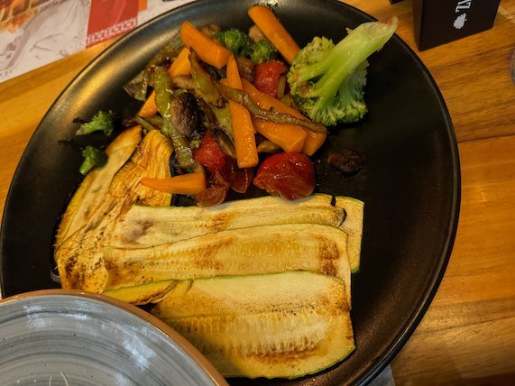 A plate of grilled zucchini, carrots and broccoli sits on a restaurant table in Skopje.
