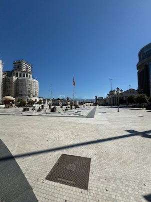 Macedonia Square spreads out wide and nearly empty under a blue sky in Skopje.