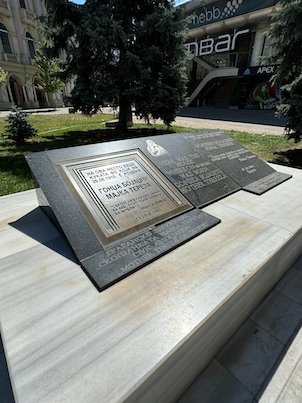A metal plaque about Mother Teresa lies on a stone base in central Skopje.