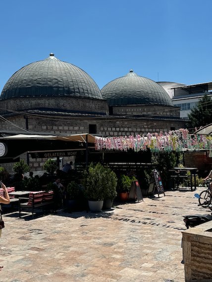 Large lead domes rise above cafe tables and plants in the Old Bazaar in Skopje.