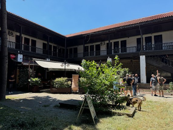 A green courtyard with a wooden gallery forms the centre of an old inn in the Old Bazaar in Skopje.