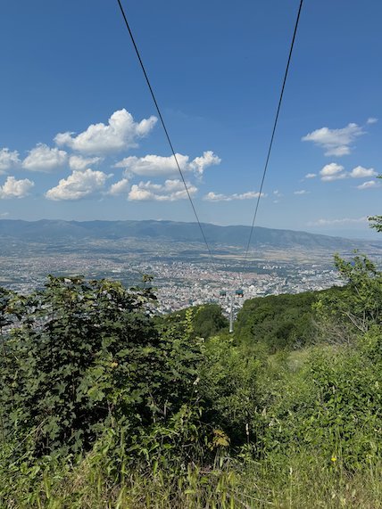 Cable car wires run down from Mount Vodno toward the city of Skopje.