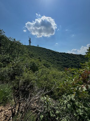 A white cloud floats above a green hillside on Mount Vodno near Skopje.