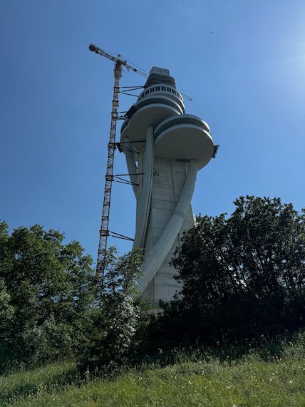 A crane stands next to a tall white tower under construction on Mount Vodno near Skopje.