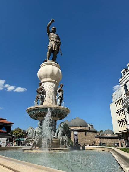 A tall warrior statue rises above a fountain near the Old Bazaar in Skopje.