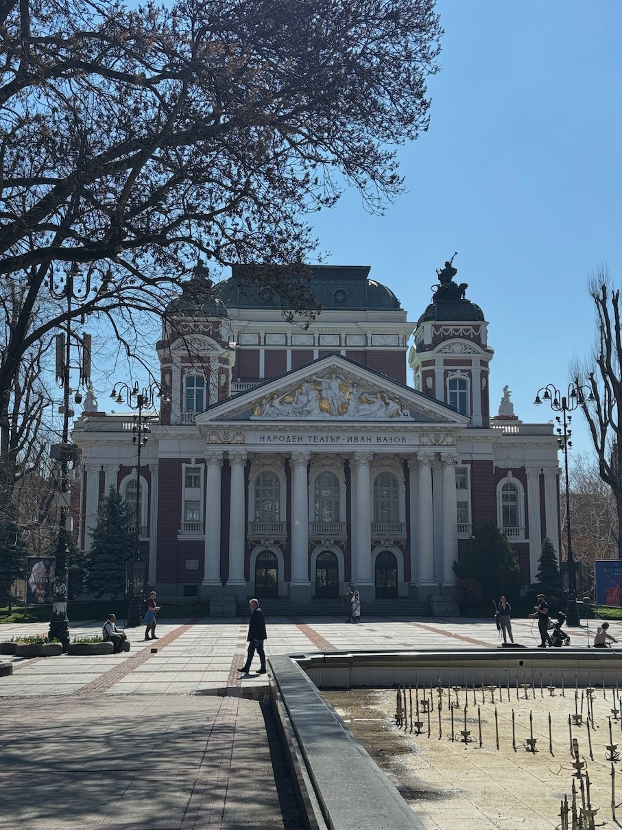The Ivan Vazov National Theatre stands at the end of a paved square in Sofia.