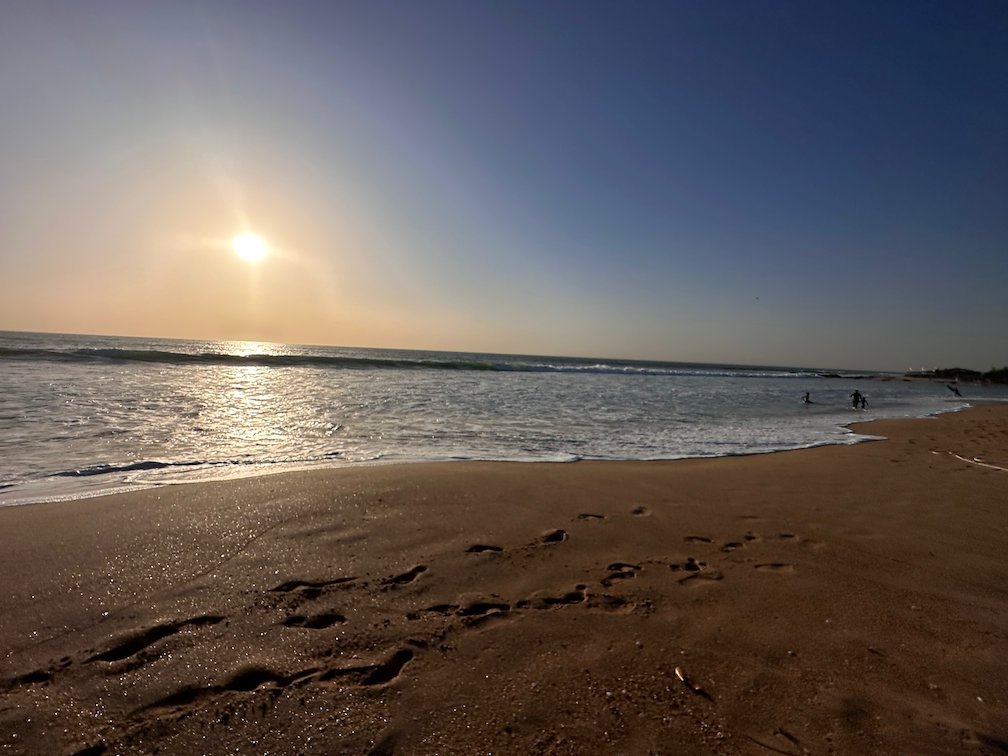 The low sun shines over the sea and the beach at Somone.