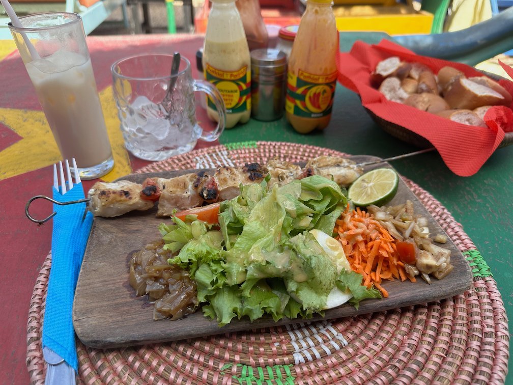 A skewer with salad stands on a wooden board on a table in Somone.
