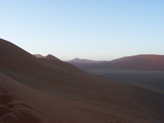Shaded dune slopes and red sand ridges stretch into the distance at Sossusvlei, Namibia.