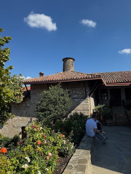 Stone building with a chimney and a flower garden at St. Stephen's Monastery