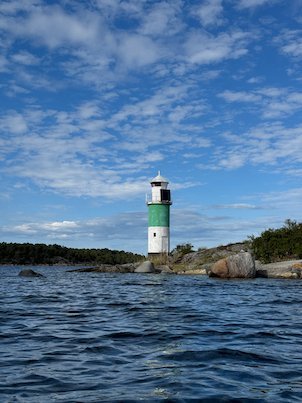 Small green and white lighthouse on a rocky skerry in the Stockholm archipelago