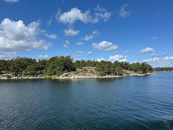Wooded island shore with summer houses, seen from the ferry