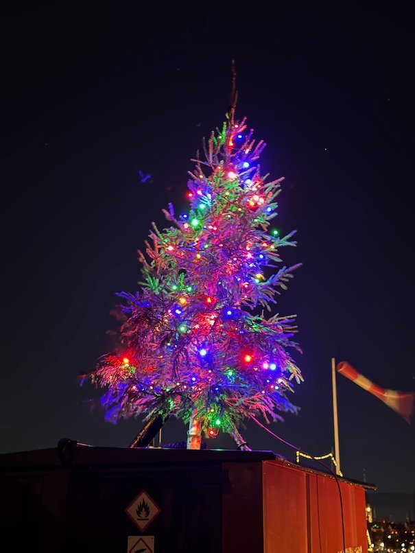 Christmas tree with red, blue and green lights against the night sky in Stockholm