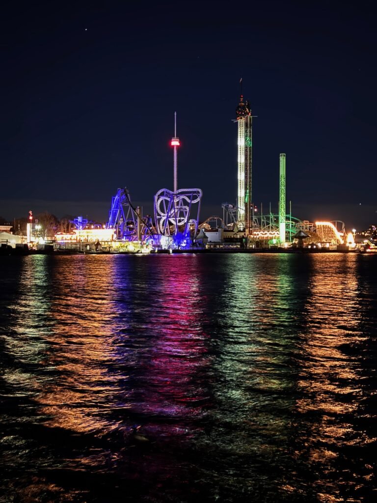 Gröna Lund amusement park in Stockholm at night, with colourful lights reflected in the water