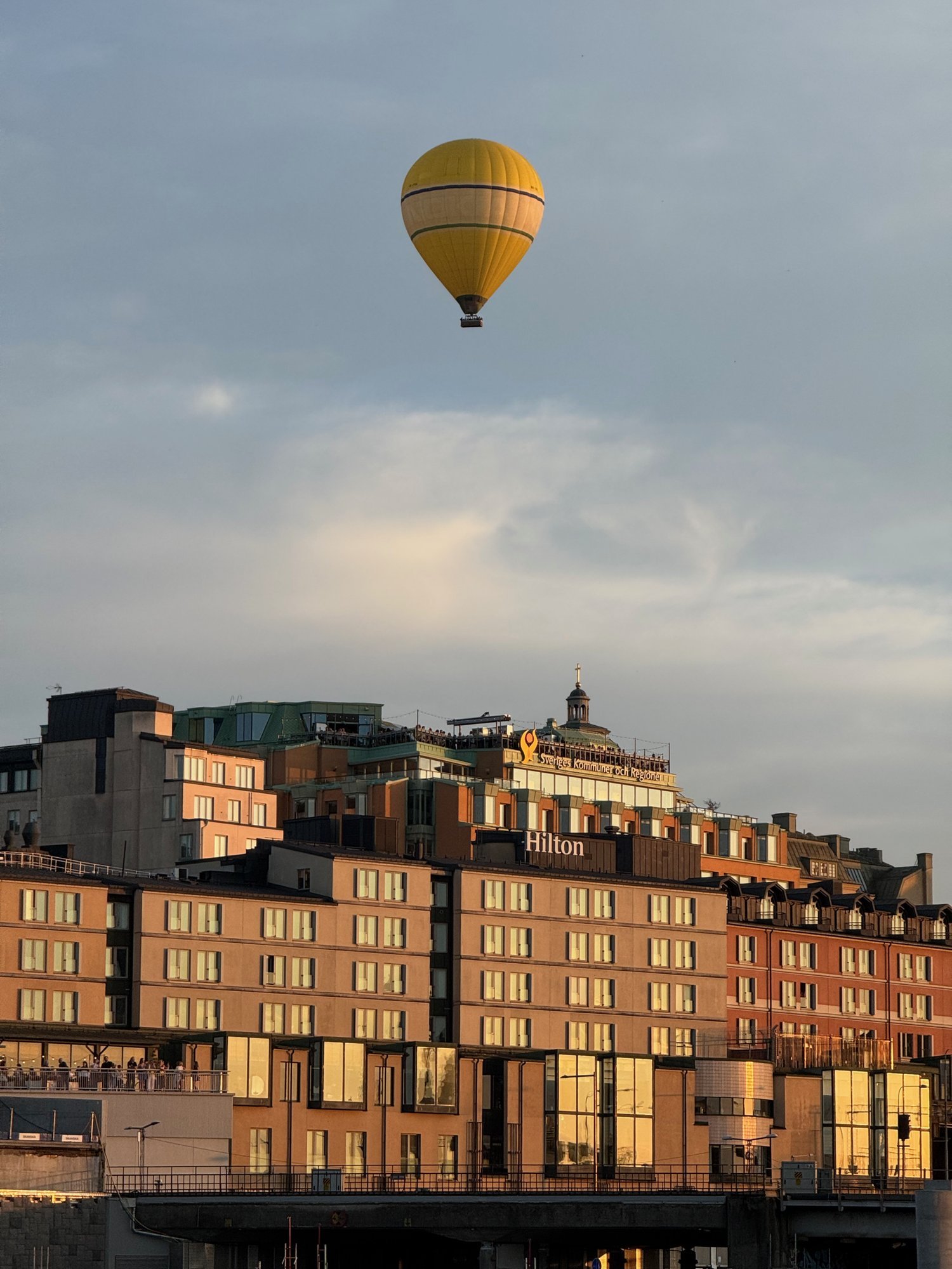 Heißluftballon über alten Häusern am Wasser in Stockholm im Abendlicht